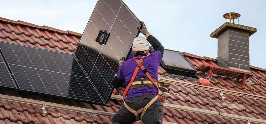 operaio specializzato che monta un pannello fotovoltaico sul tetto